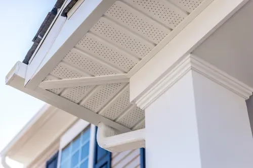Detailed view of a white perforated soffit and supporting column on a modern home exterior